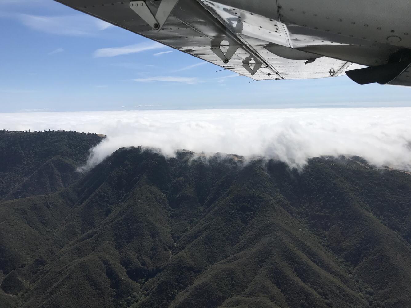 Fog over mountains viewed from the side of a plane