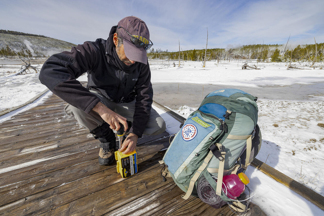 YVO scientist replaces batteries in a temperature logger (Norris Basin)