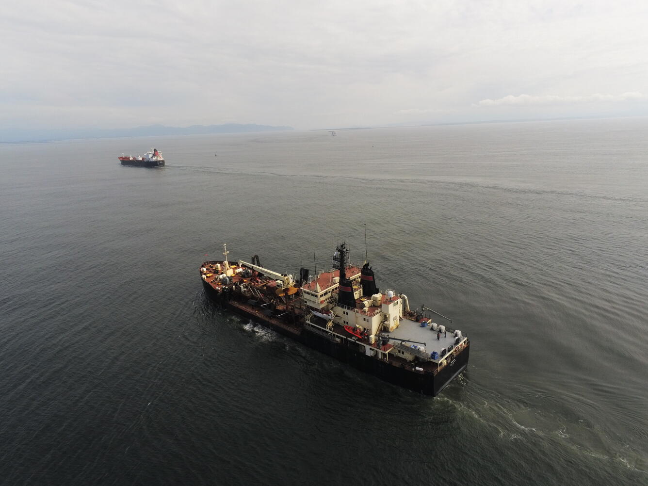 Aerial photograph of two dredging vessels at the Columbia River mouth