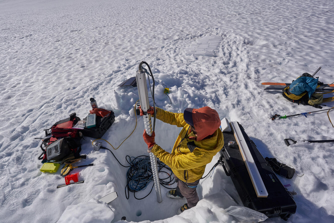 A scientist prepares to extract a snow core from one of the Benchmark Glaciers.  