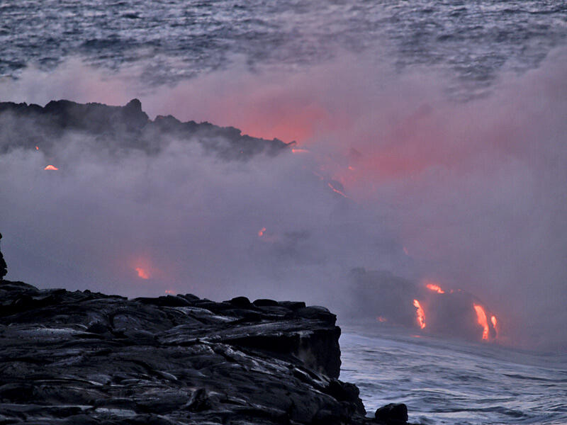 This is a photo of small cascades of lava entering the water as other breakouts appear on delta.