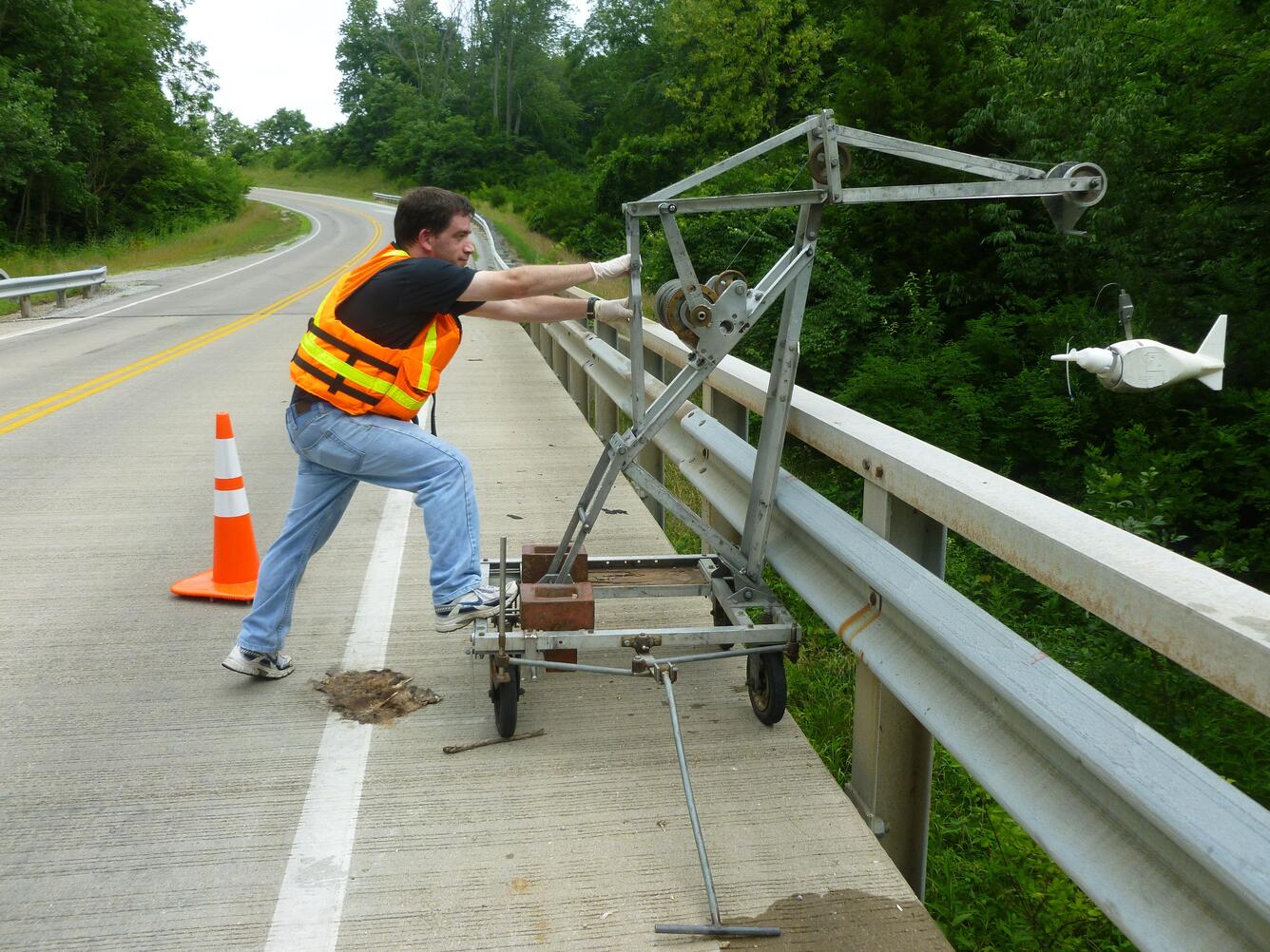 USGS Hydrologist Dan Button maneuvers an isokinetic sampler into  Massies Creek, in Wilberforce, Ohio. 