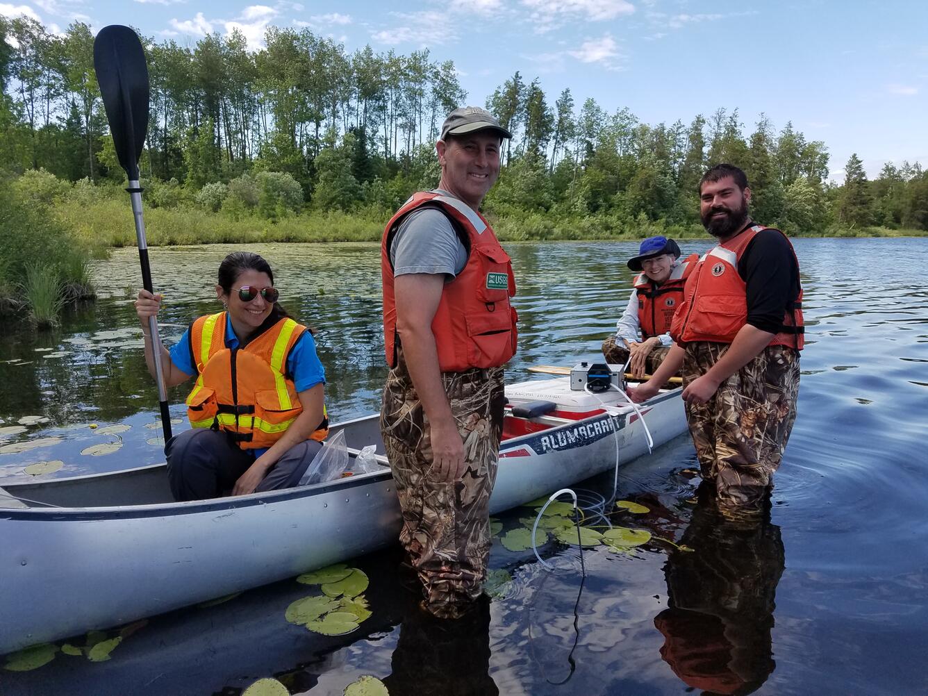 Four USGS scientists on a canoe sampling pore water water