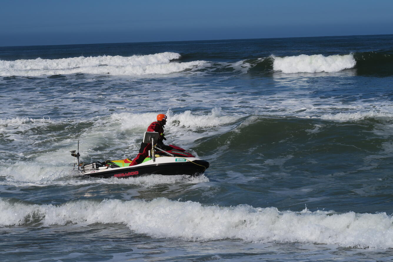 USGS scientist Jackson Currie navigates a personal water craft through waves, collecting bathymetric data in Monterey, CA