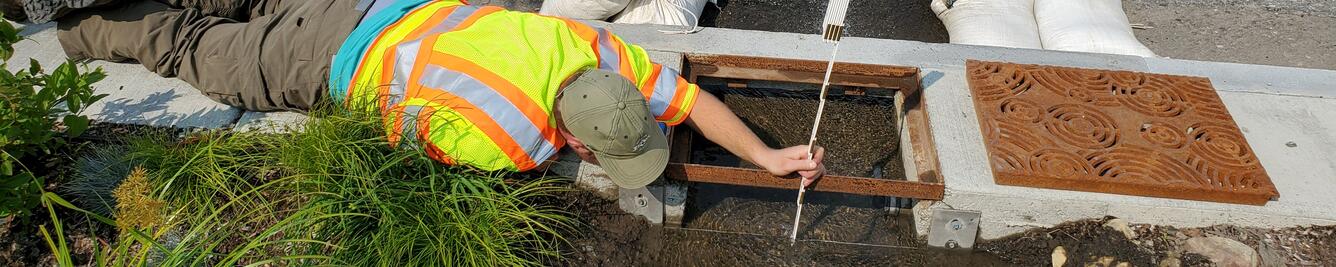 scientist calibrating green infrastructure storm planter inlets in urban area