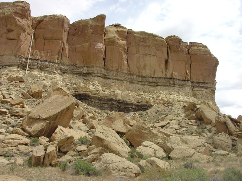 This is a photo of a cliff and talus slope located next to the parking area for the Chaco Canyon Visitor Center.