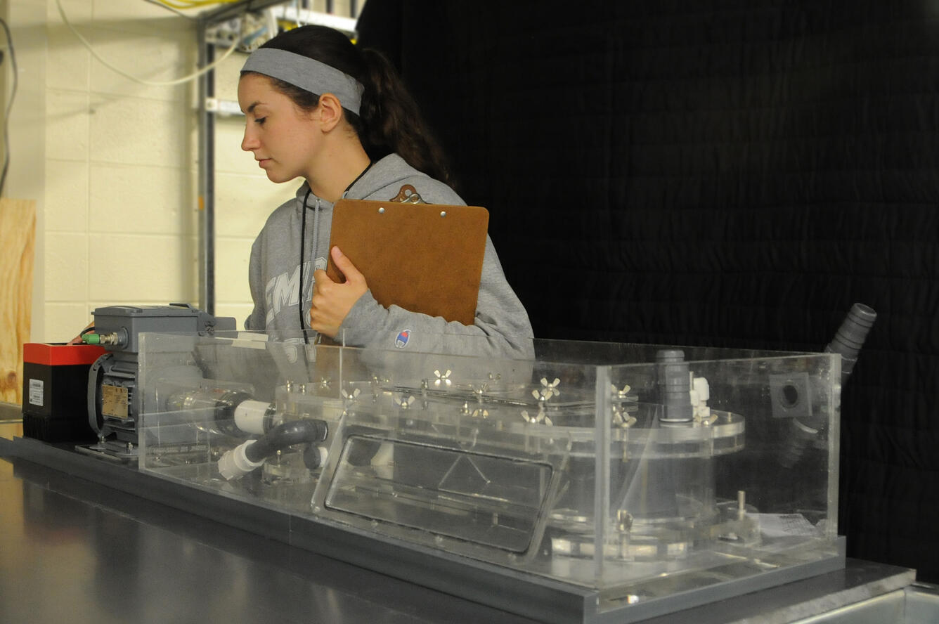 A female scientists overlooks swimming chambers for pallid sturgeon