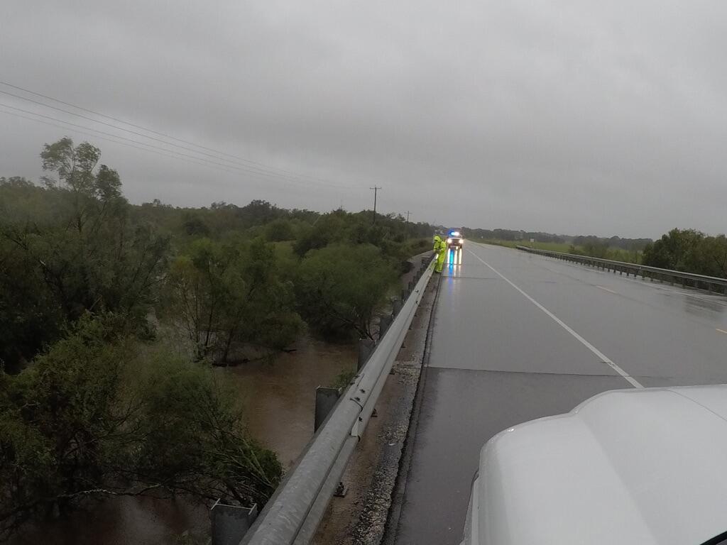 Image shows a highway with a flooding river underneath