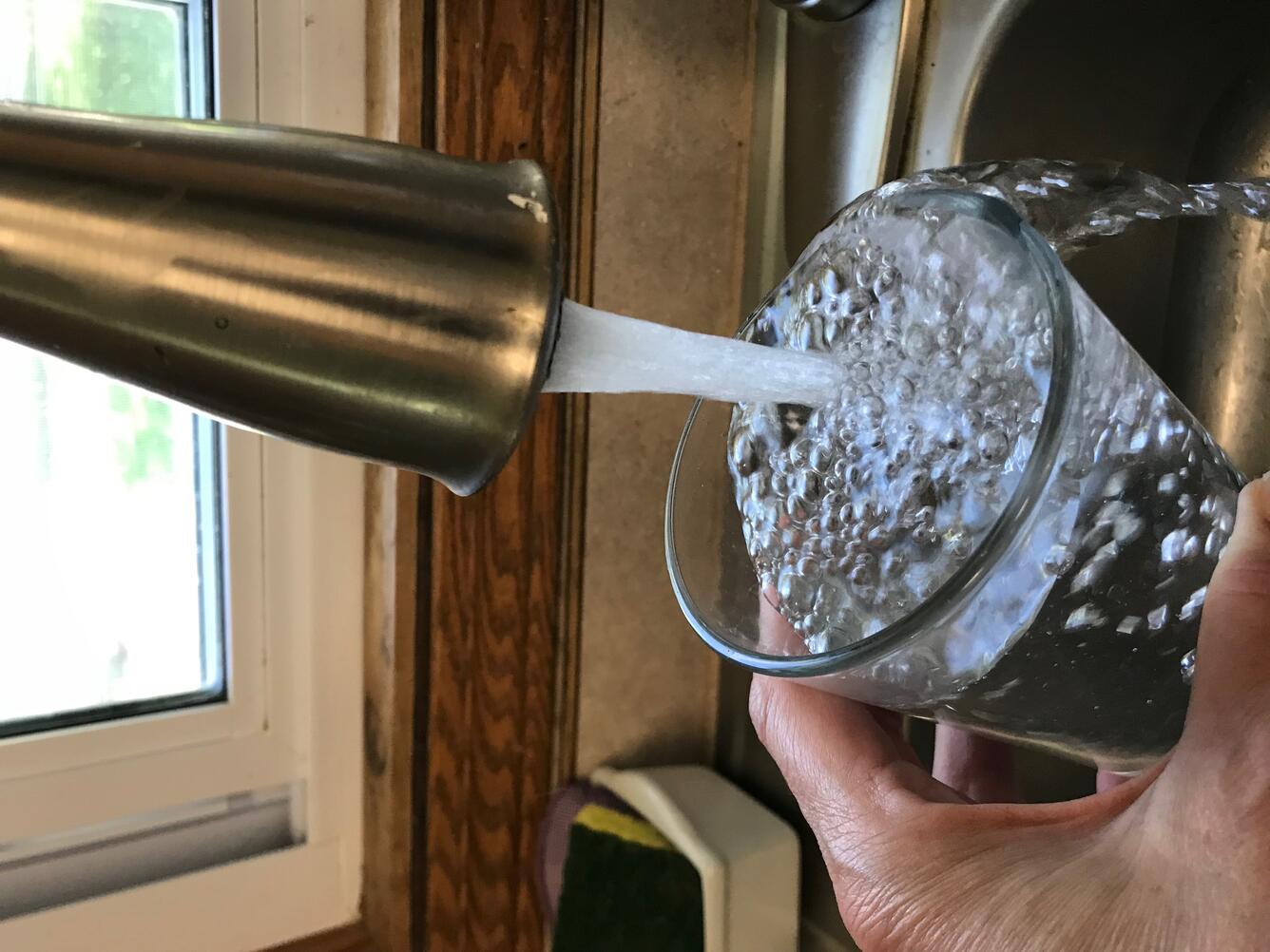 water glass filling in kitchen sink