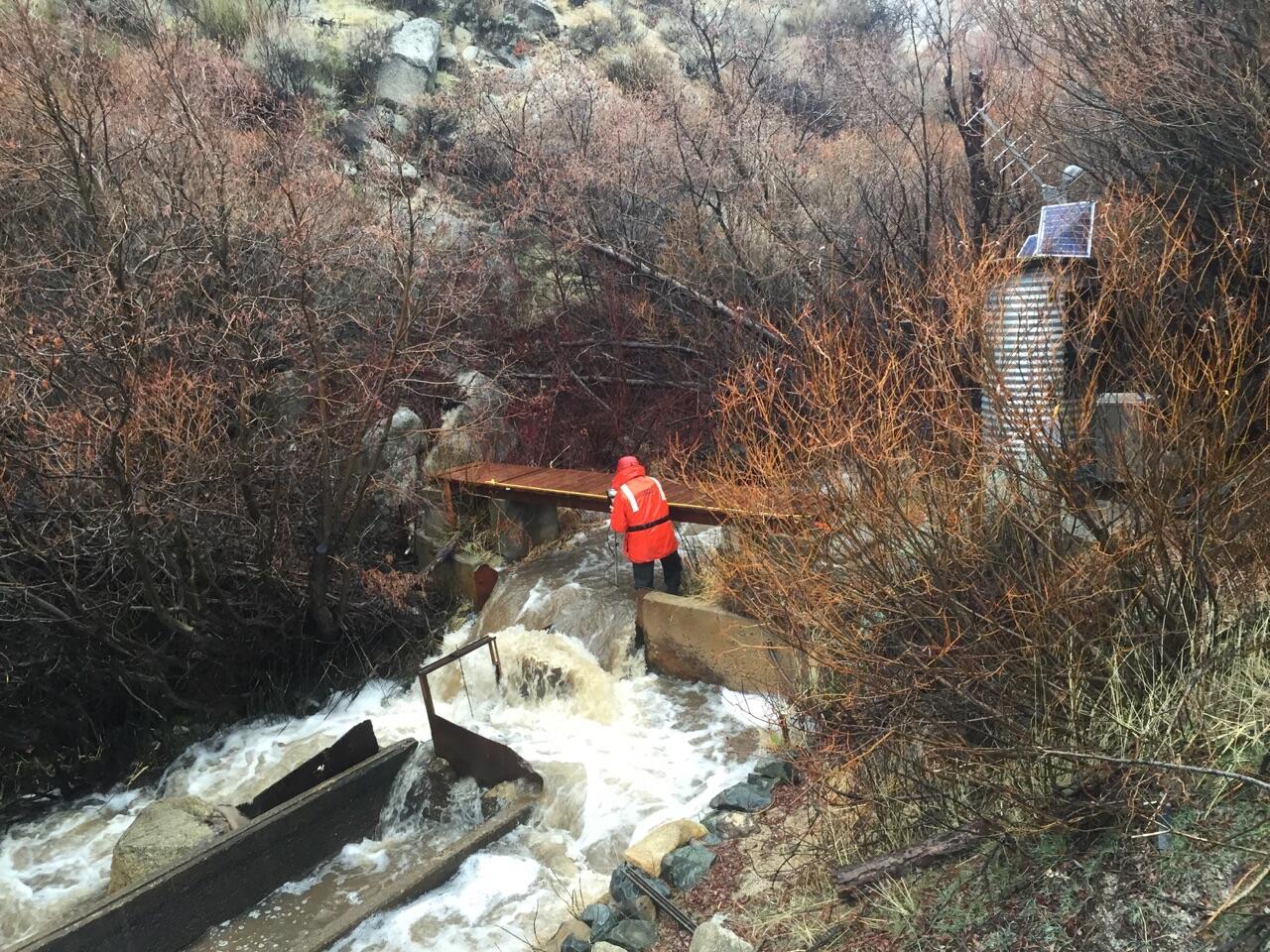 clear creek with scientist adjusting automatic sampler