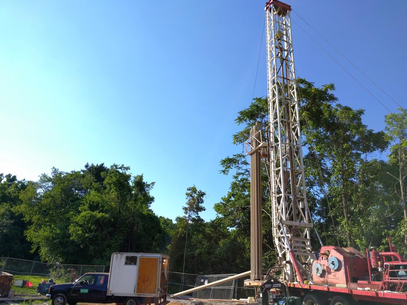 towering drill rig with a USGS truck in background