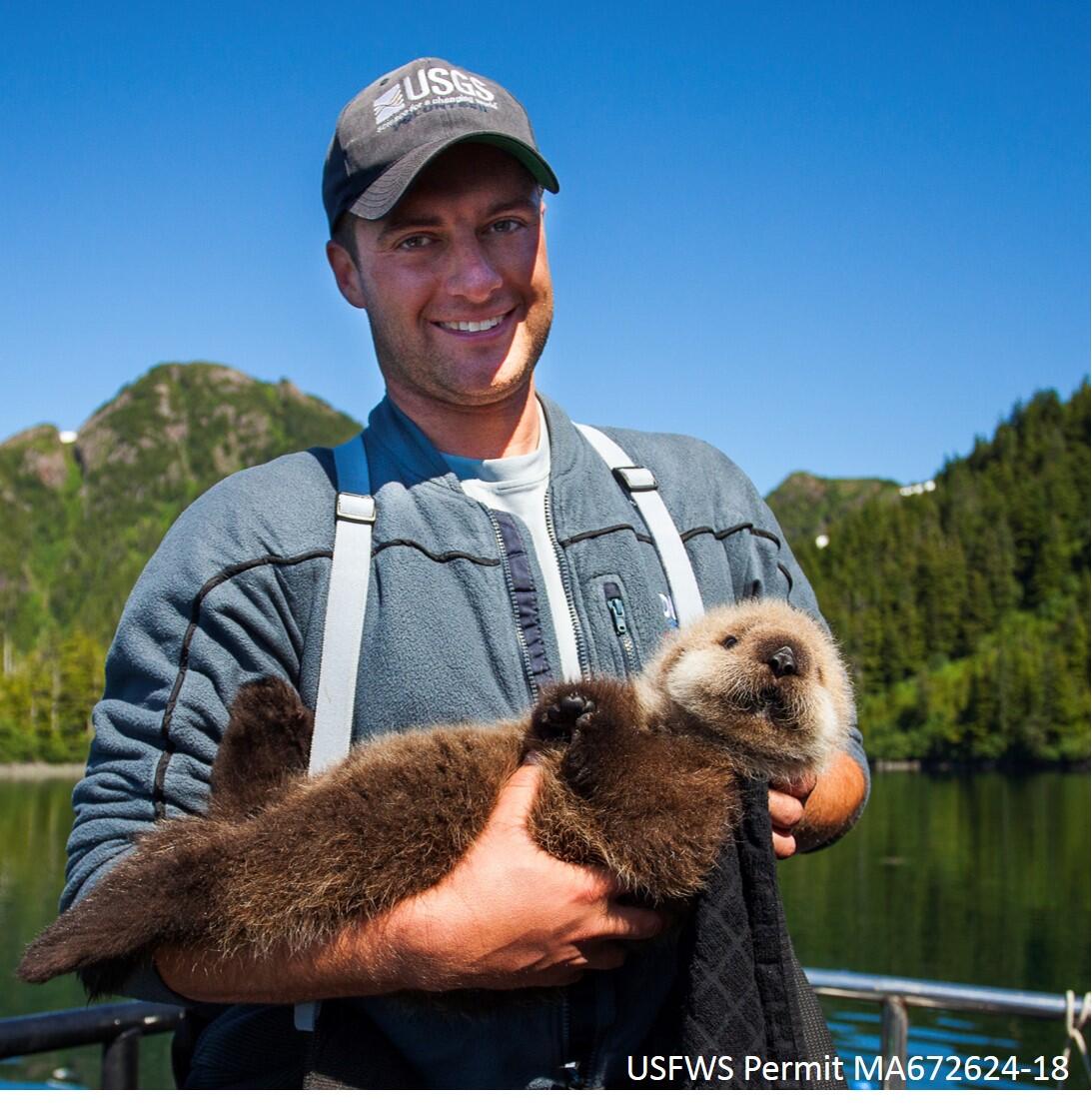Photo of biologist, Joe Tomoleoni, holding a sea otter pup