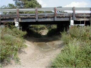 Bridge over dry stream bed due to low flow conditions.