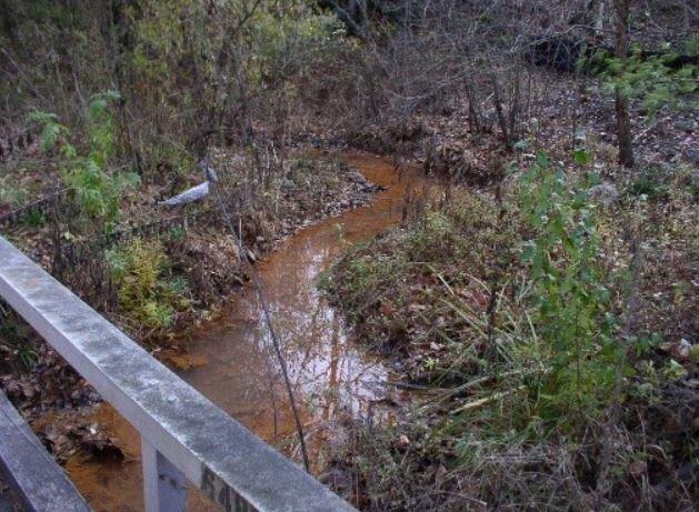 Orange-stained Ely Creek as a result of acid mine drainage