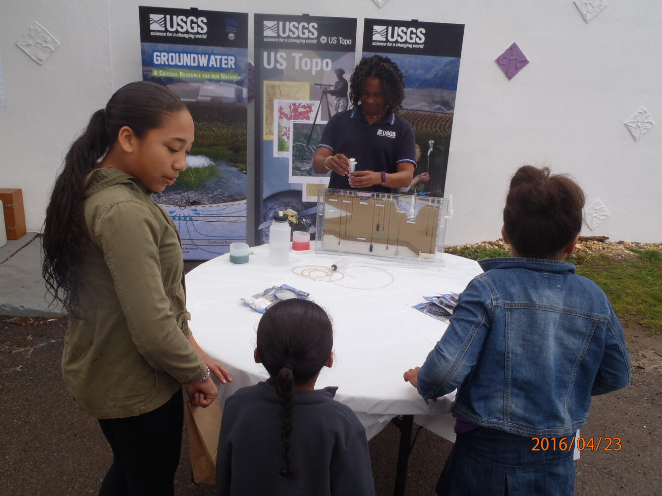 Photo of Simonette Rivera, hyrdrologic technician demonstrating ground water flow using a ground water model.