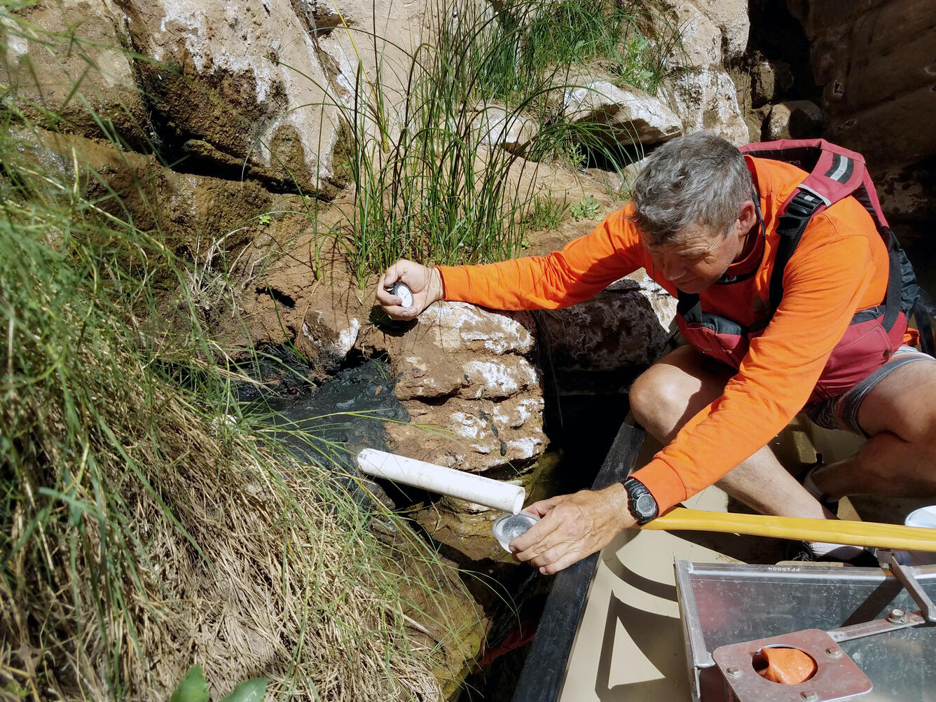 Photograph of Hydrologic Technician making a volumetric discharge measurement at a spring near Clear Creek, Arizona