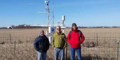Photograph of scientists in front of a carbon flux tower located in SD.