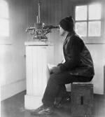 A person sitting at a monitoring device for geomagnetism.