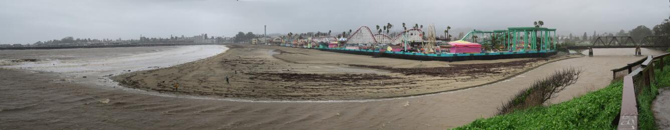 Panoramic view of the mouth of the San Lorenzo River at the beach with amusement park in background.