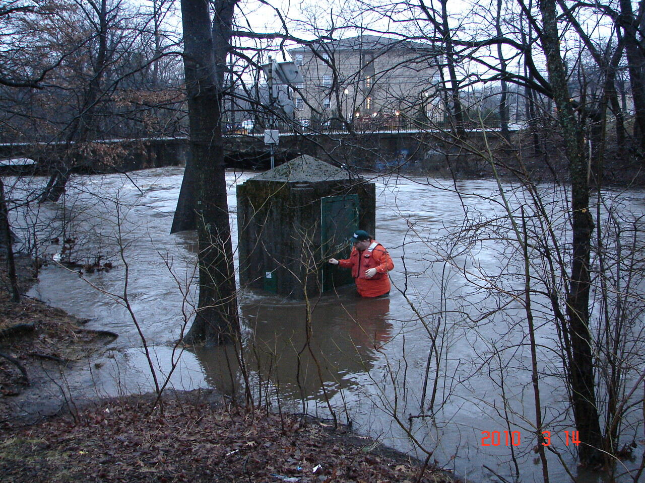 Hydrographer Wading into floodwaters to reach a gage