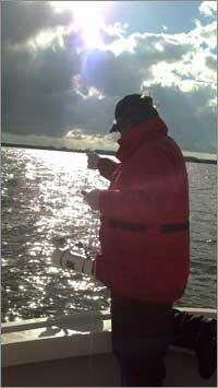 Picture of scientist taking water sample from Currituck Sound