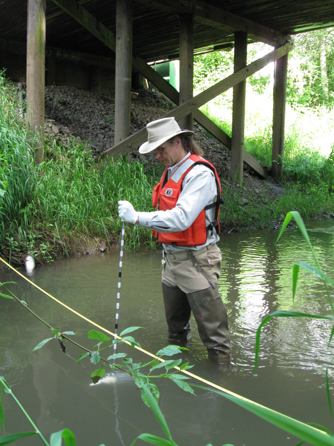 USGS scientist collecting a water-quality sample from Zollner Creek, Oregon
