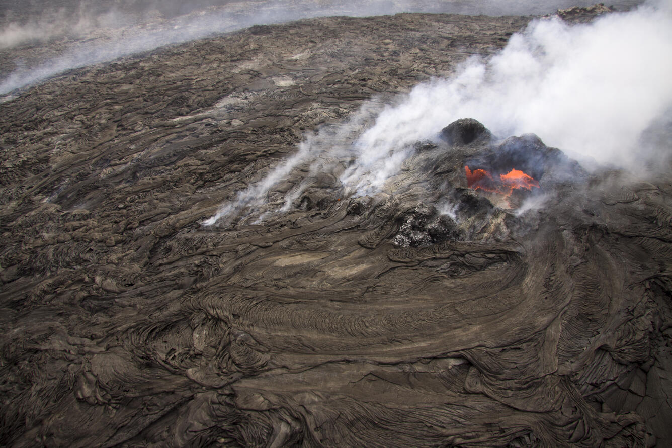 This is a steep aerial view of the small lava pond at the top of th...