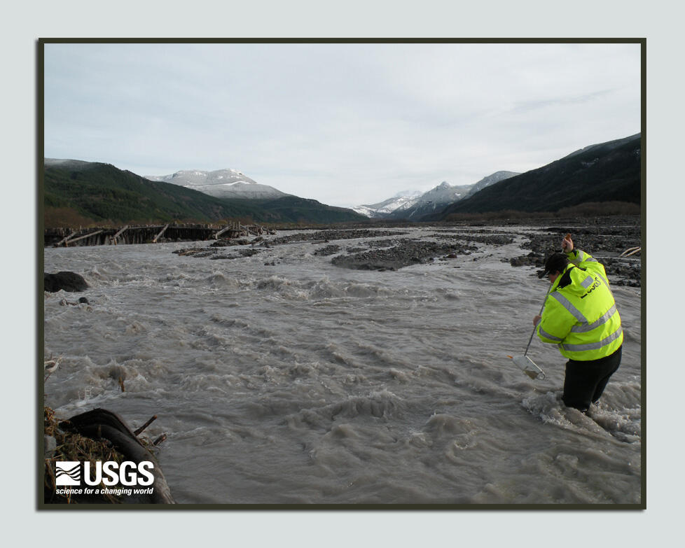 USGS scientist wades into river to collect sediment sample...