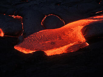 This is a photo of lava pouring slowly from under crust within Banana flow.